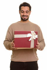 Young happy Indian man opening gift box ready for Valentine's da