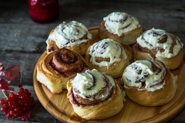 Freshly baked cinnamon buns with spices and cocoa filling on parchment paper. Christmas concept. Sweet Homemade Pastry christmas baking. Kanelbule - swedish dessert. Still life of food. Jam. viburnum