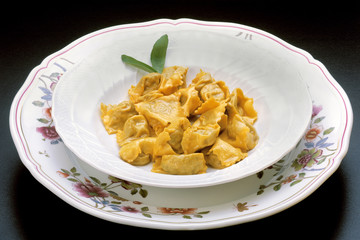 Italian food recipes, traditional fresh Pasta Agnolotti stuffed with meat, cheese, spinach in sage and butter sauce.