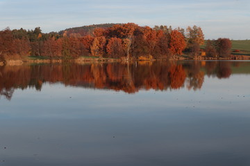 Herbstlandschaft spiegelt sich auf einem See