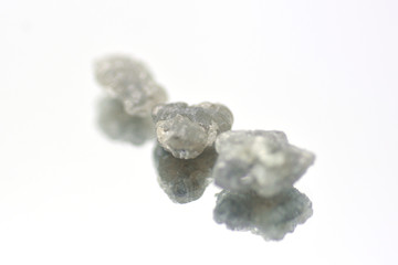 Three rough diamonds on a mirror