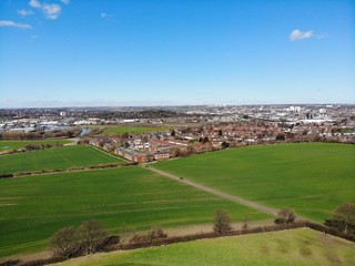 Fototapeta na wymiar Aerial shot of a town in the UK overlooking a farmers field.