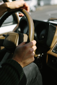 Hands Gripping Steering Wheel of Car