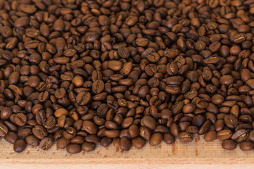 Closeup of fragrant roasted coffee beans on a wooden board. Selective focus. place for text.