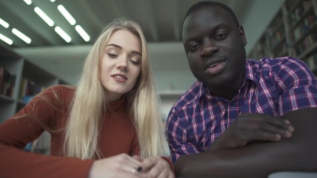 African american male and caucasian female talk to camera