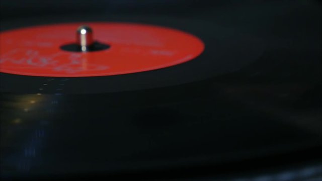 A needle is put down on the spinning black vinyl record on the turntable