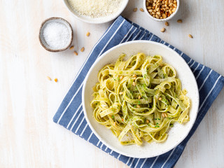 Tagliatelle pasta with pesto sauce made of Basil, garlic, pine nuts, olive oil. Top view, copy space