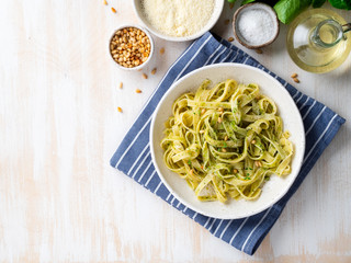 Tagliatelle pasta with pesto sauce made of Basil, garlic, pine nuts, olive oil. Top view, copy space