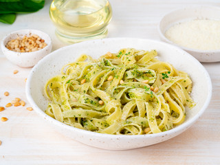 Tagliatelle pasta with pesto sauce made of Basil, garlic, pine nuts, olive oil. Side view