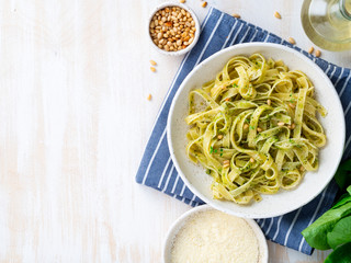 Tagliatelle pasta with pesto sauce made of Basil, garlic, pine nuts, olive oil. Top view, copy space