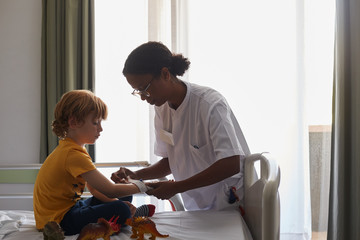 Doctor female giving attention and care to child in a hospital room