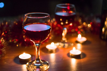 Glasses with red wine. Garlands in the background.