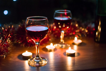 Glasses with red wine. Garlands in the background.