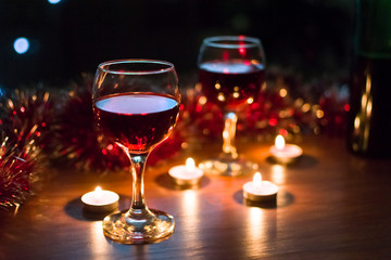 Glasses with red wine. Garlands in the background.