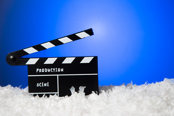 Frozen film clapper / clapperboard with copy space on blue background.