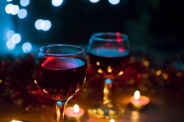 Glasses with red wine. Garlands in the background.