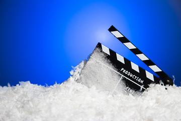 Frozen film clapper / clapperboard with copy space on blue background.