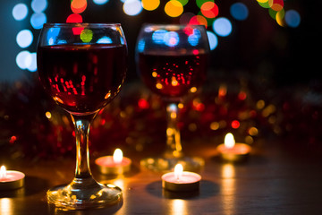 Glasses with red wine. Garlands in the background.