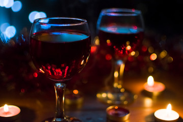 Glasses with red wine. Garlands in the background.