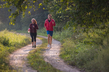 Fototapeta premium young couple jogging along a country road
