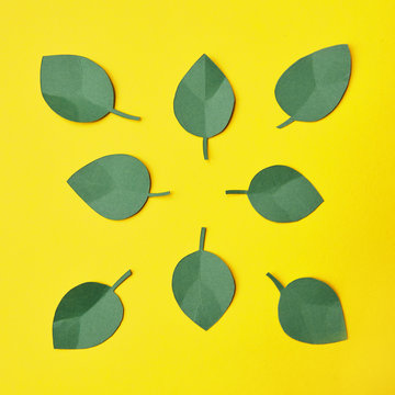 Paper craft green leaves over yellow