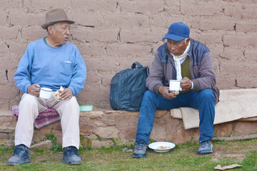 Native american old men eating outside.