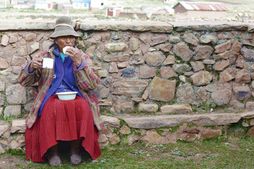 Old native american woman eating outside.
