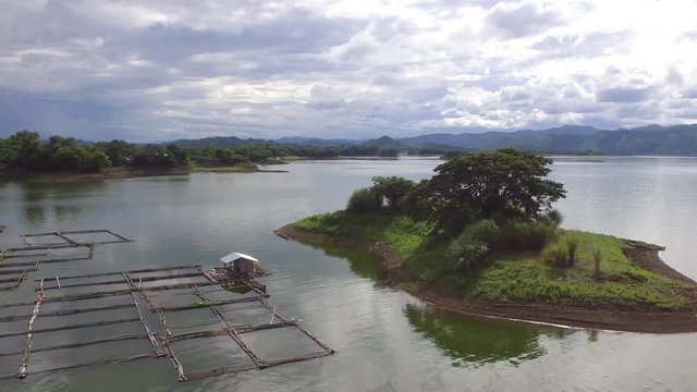 Alfonso Lista, Ifugao, Philippines - August 27, 2017: floating shanty, fish cages built on the lake hydro electric dam reservoir. drone aerial shot