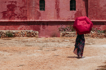Young lonely woman with a red umbrella