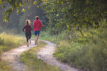 Obraz premium young couple jogging along a country road
