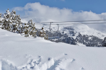The area of chairlift in the mountains over deep snow