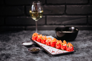 Various kinds of tasty sushi served on black stone