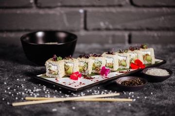 Various kinds of tasty sushi served on black stone