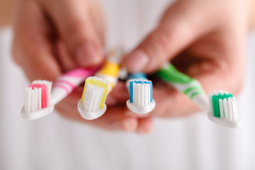 Woman holding manual toothbrushes