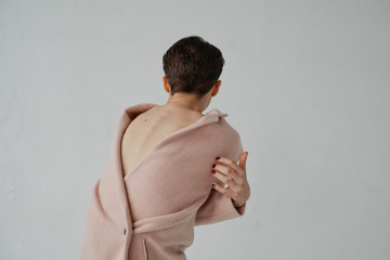 Sensual woman in coat posing on white background