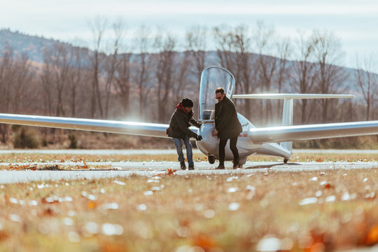 Friends pulling glider from the runway after flight