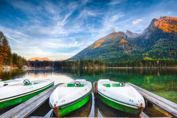 Fantastic autumn evening at Hintersee lake. Few boats on the lake