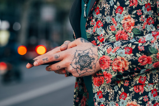 Tattooed handsome man with colourful flower jacket around the city.
