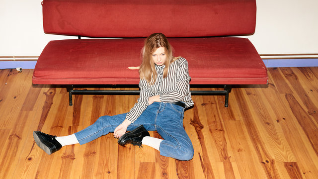 Model sitting unemotionally on floor