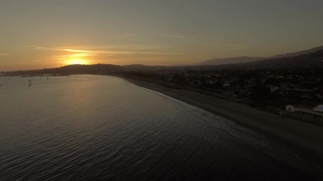 Drone flying over Santa Barbara ocean watching vibrant sunset