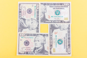 Fototapeta na wymiar Different American dollars on the light yellow base