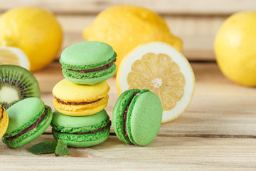 Green and yellow french macarons with kiwi, lemon and mint decorations