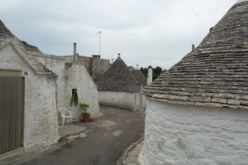 Unique small South Italia city Alberobello with antient stones conical houses trullo, tourist...
