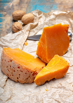Pieces of native French aged cheese Mimolette, produced in Lille with greyish curst made by special cheese mites
