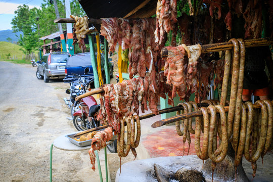 Original Caribbean food on the roadside in the Dominican Republic. Smoked pork, morcillas and longanizas.