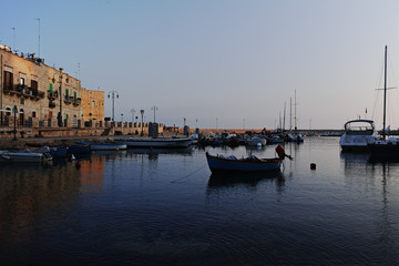 Fototapeta premium Old fishing harbor with colorful wooden boats in old small city Giovinazzo near Bari, Apulia, Italy in early morning