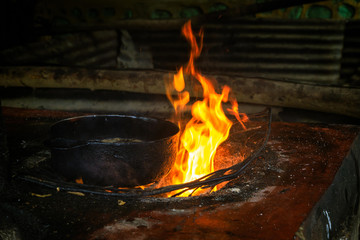 Open cooking place with fire and a kettle for deep frying