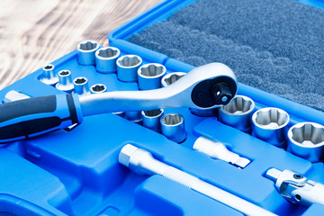 set of heads for car repairs. ratchet on a wooden blue background. ratchet close-up