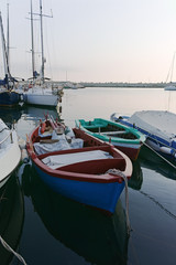 Old fishing harbor with colorful wooden boats in old small city Giovinazzo near Bari, Apulia, Italy in early morning