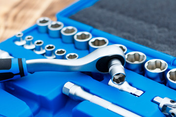 set of heads for car repairs. ratchet on a wooden blue background. ratchet close-up